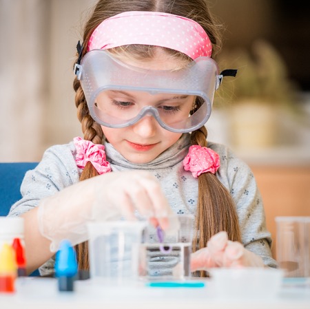 happy little girl with flasks for chemistry homeschool