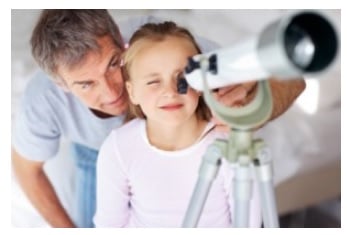 The girl is observing astrology through a telescope with her dad
